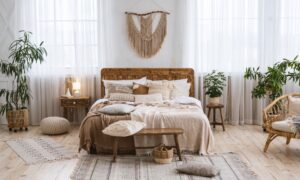 The interior of a rustic bedroom with wood floors and decorations plus a bed with a comforter and several pillows.