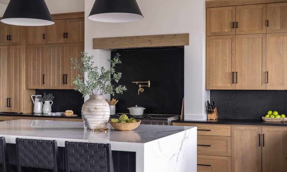 A modern, luxurious kitchen interior is decorated with wooden cabinets, wooden accent pieces, and a vase with a plant.